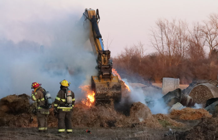 A backhoe operated by Dan McNally moved flaming hay out of the way.